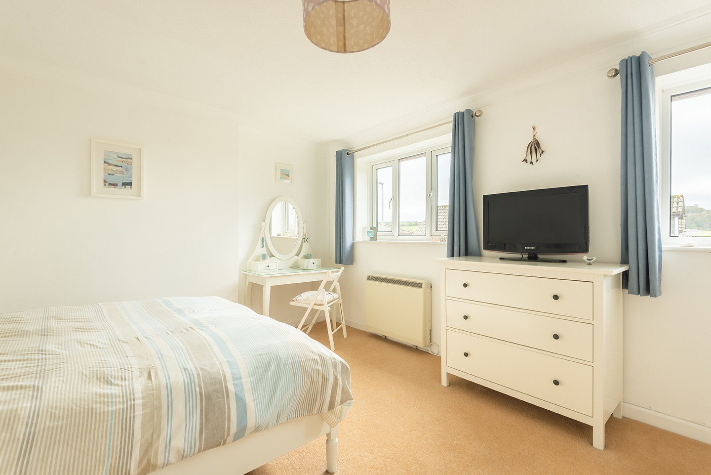 The spacious, light master bedroom looks out over the village and towards the countryside beyond