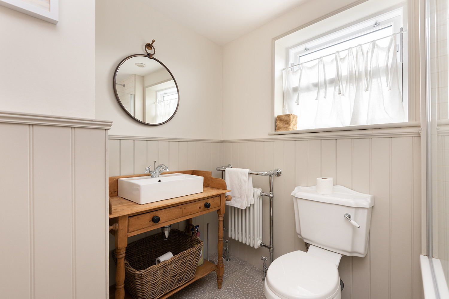 The family bathroom with beautiful vintage style sink and pattern tiled floor.