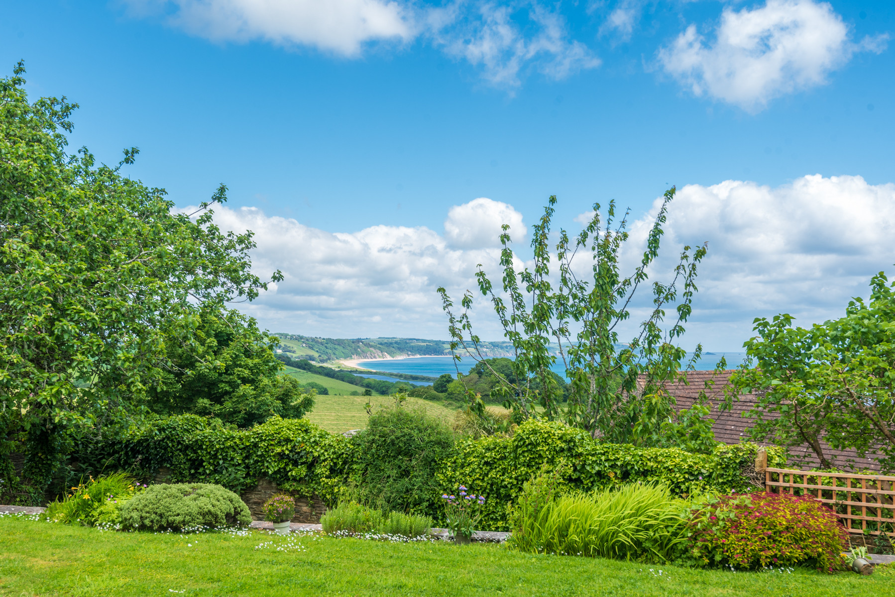 A beautiful garden looking down over the fields to Start Bay from this pretty holiday home in Devon