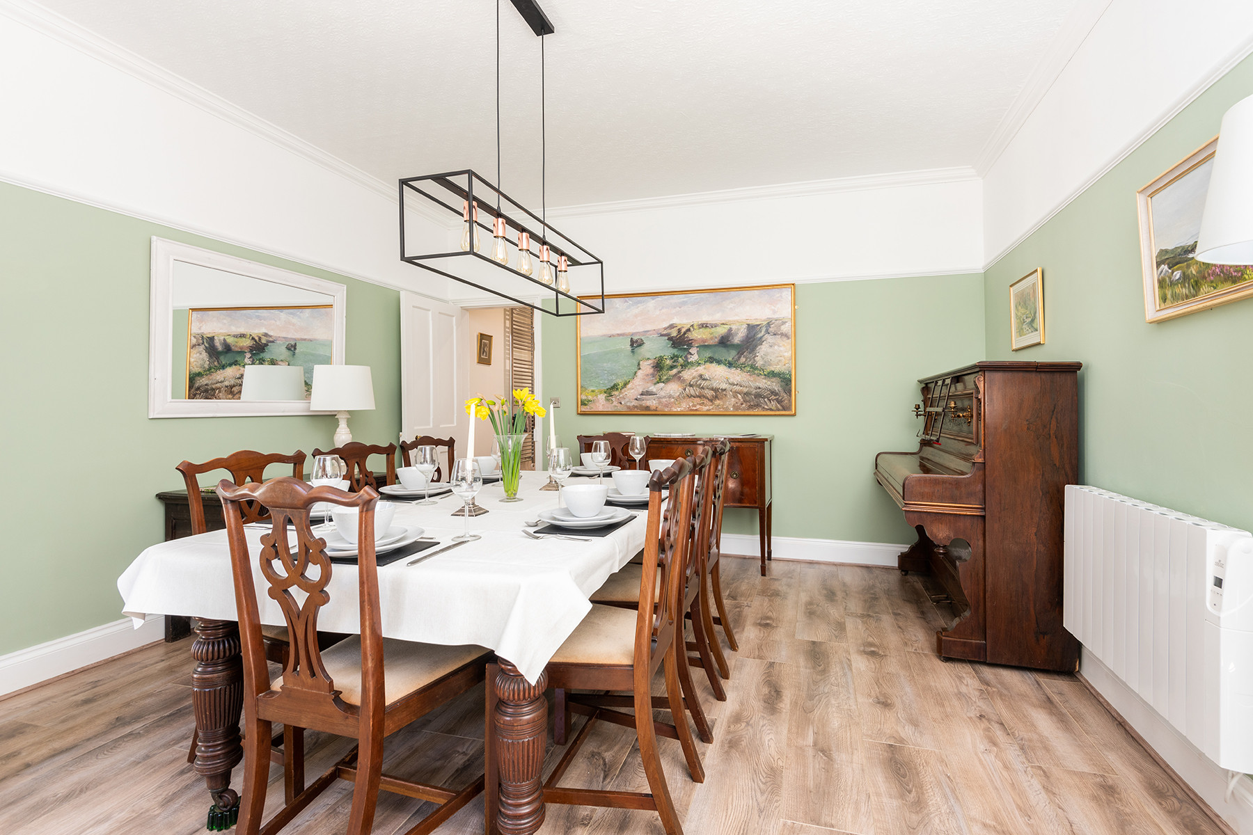 Spacious dining room with large dining table seating for 8, with upright piano
