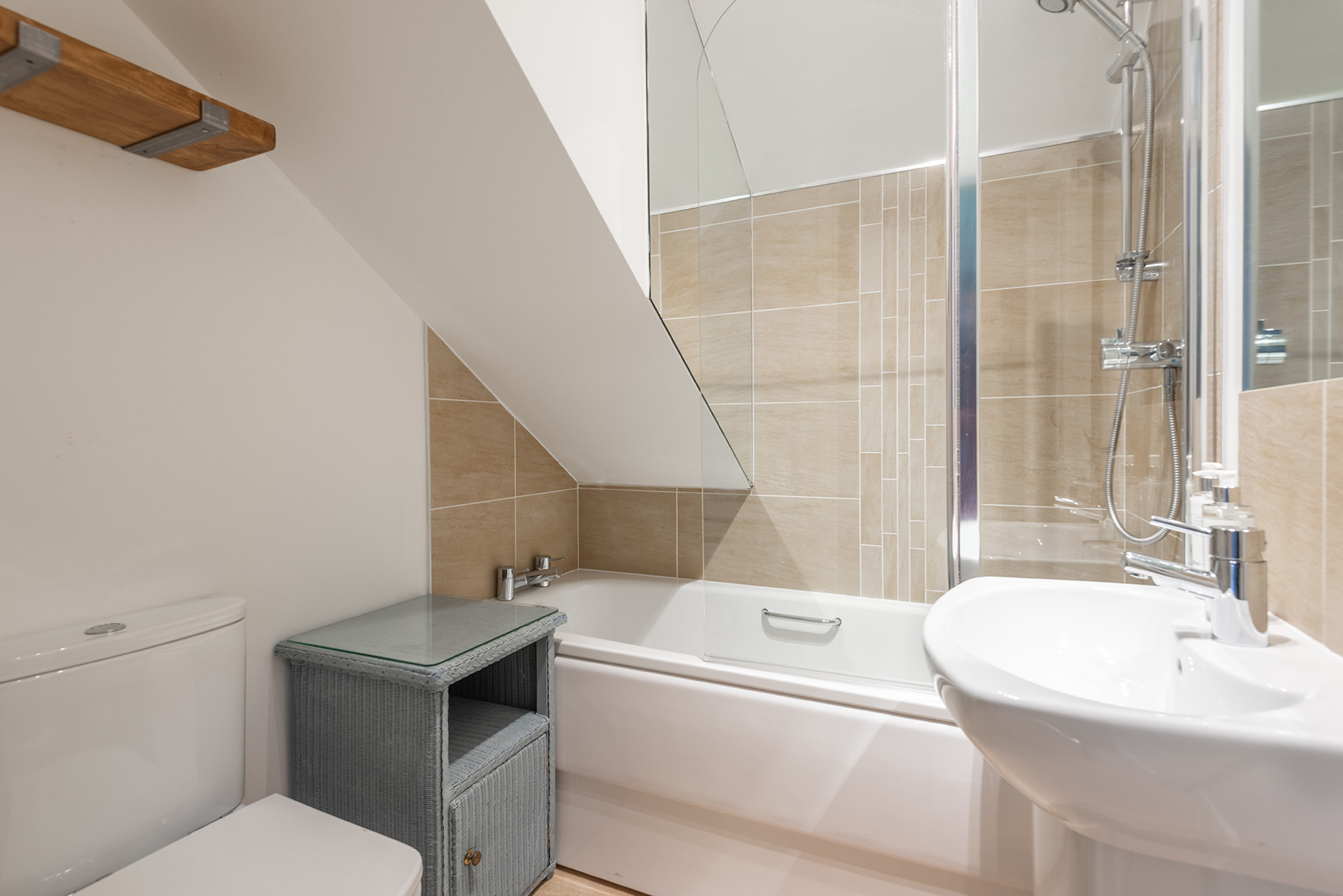 The bathroom with bath and over head shower