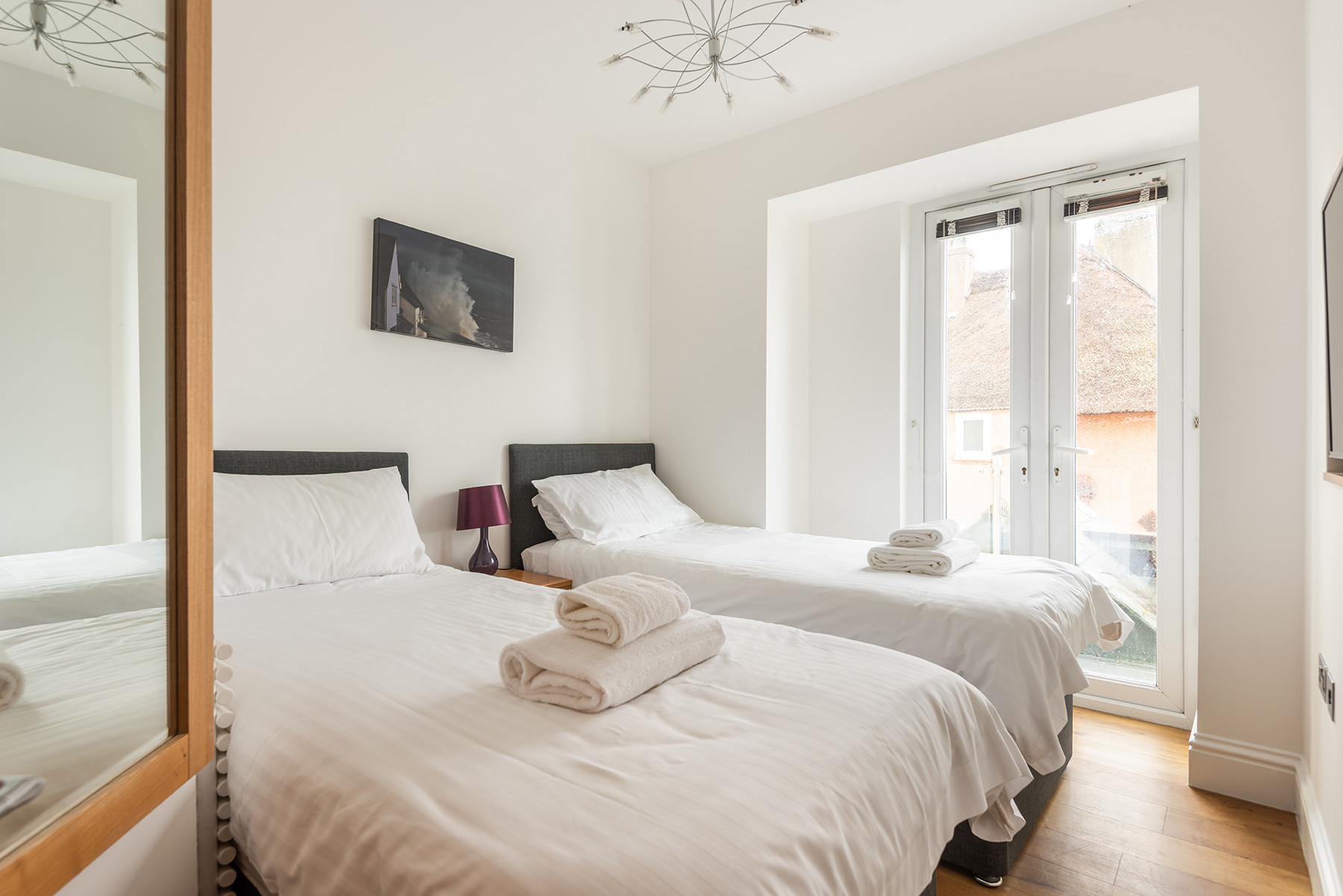 Bedroom 2- a small twin room with TV and views out to sea