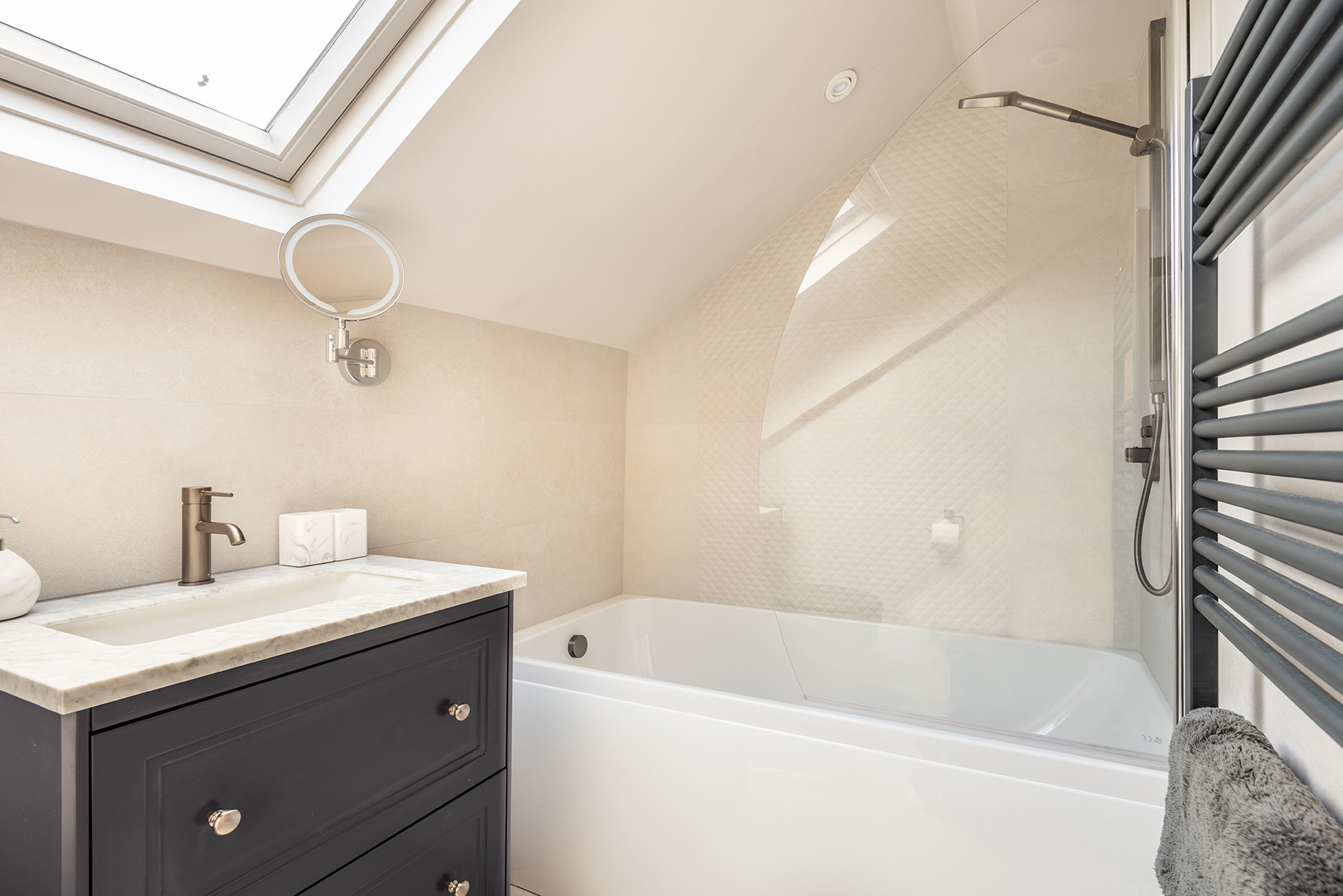The bathroom with shower over the bath